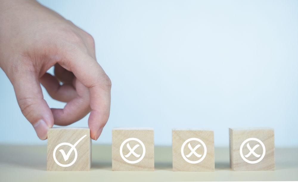 image_A,Hand,Selects,A,Wooden,Cube,With,A,Check,Mark