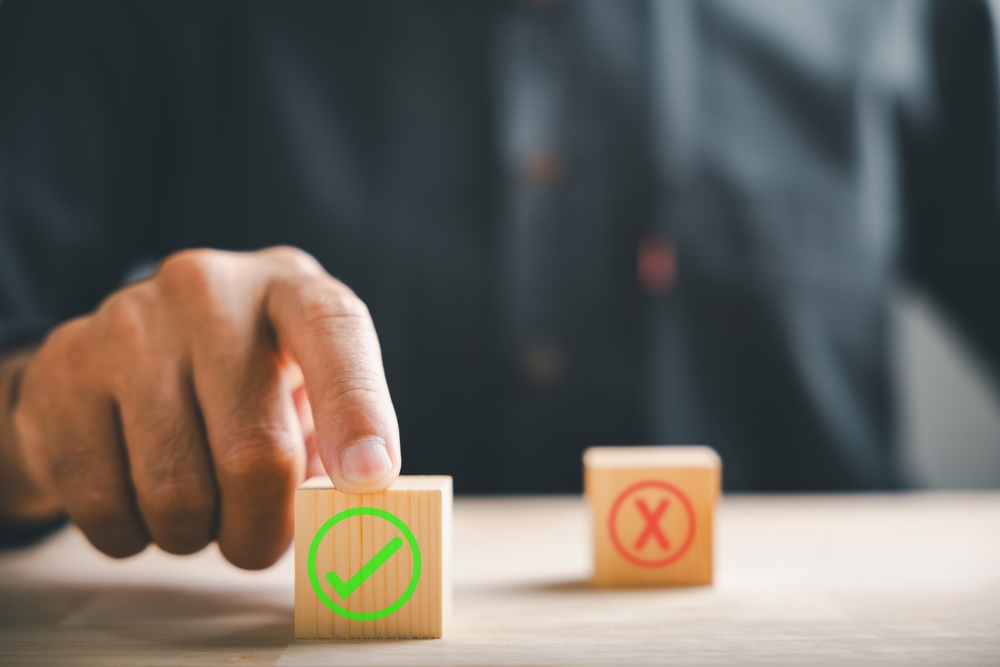 image_Finger,Of,Businessman,Touches,Wooden,Cubes,With,Check,Marks,Showing